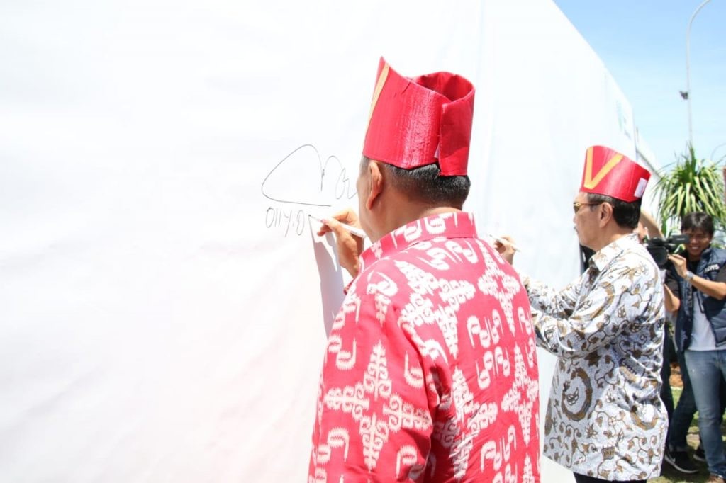 Menko Kemaritiman dan Investasi RI Luhut Binsar Panjaitan didampingi Gubernur Sulut Olly Dondokambey saat menandatangani ikrar ekowisata pada spanduk yang telah disiapkan panitia AIS Forum 2019.(Foto: hbm)